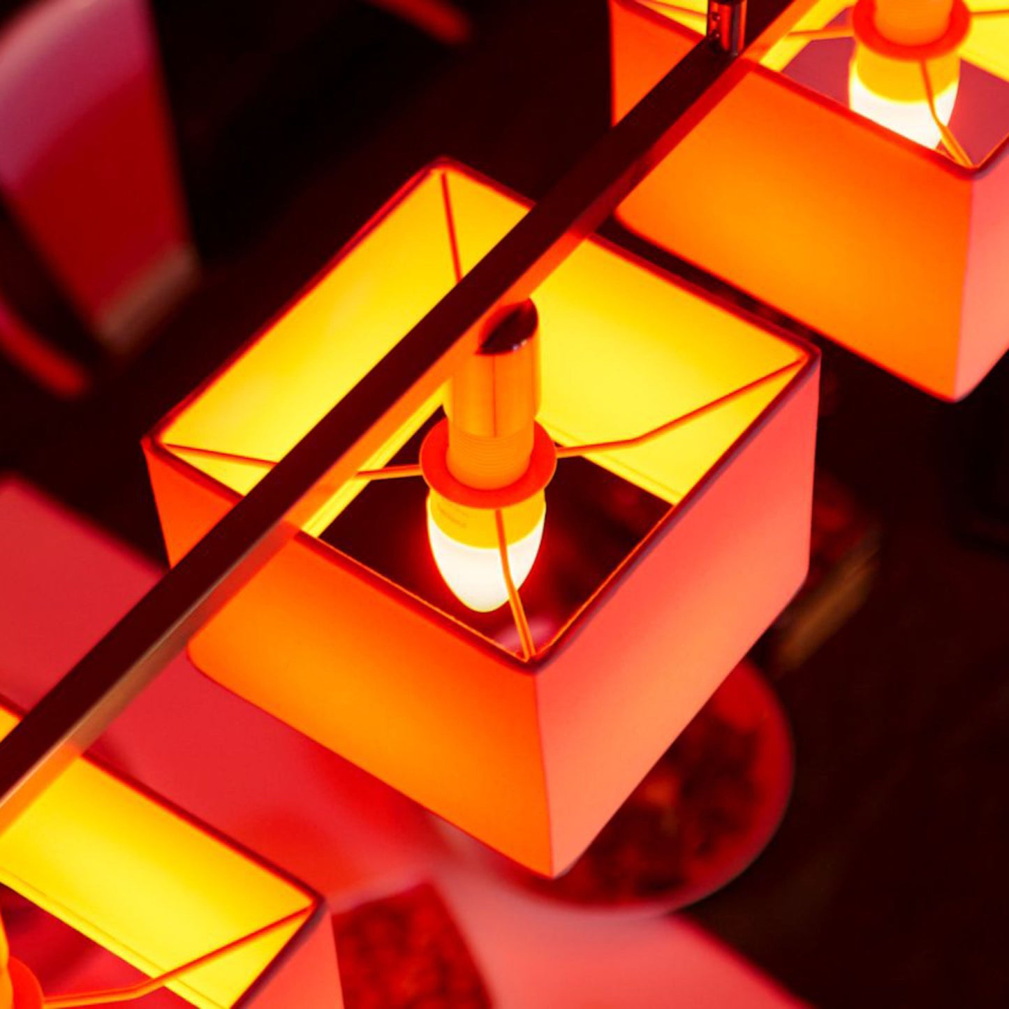 Philips Hue Color Ambiance Smart LED-pære E14 470 lm 2-pak, tændt med varm gul-orange lyseffekt.