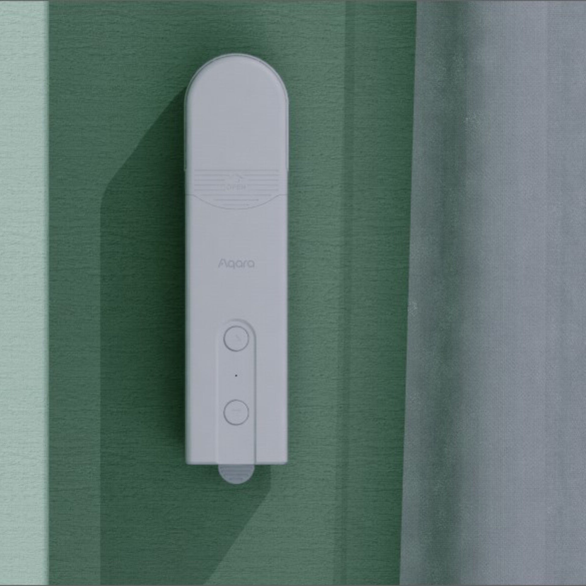 Aqara Rullegardin Driver E1 gardinkontrol monteret på grøn væg ved siden af let gennemsigtigt gardin.