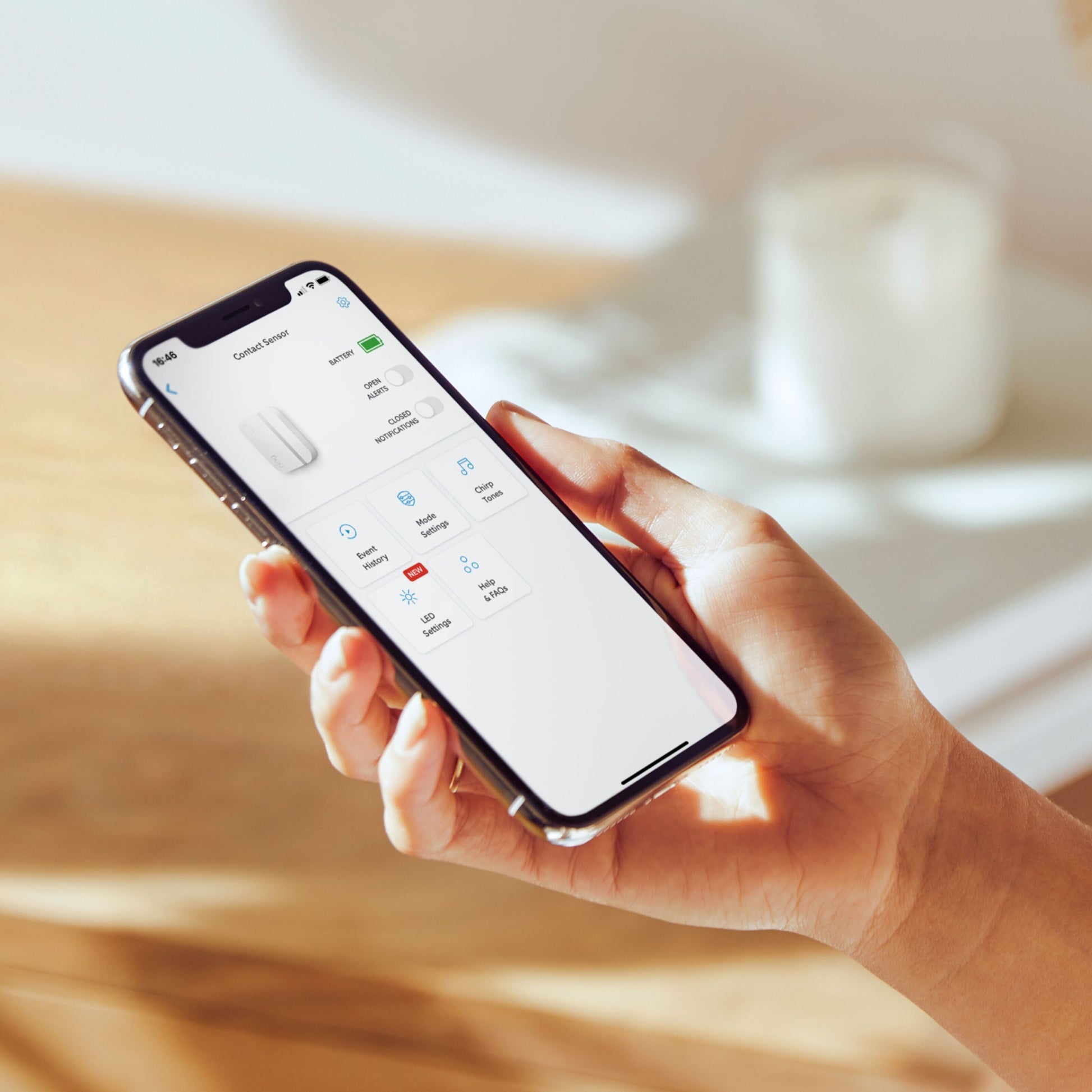 Ring Alarm 2. gen app vises på smartphone med kontroller for lys, stik og sensorer, interface tydeligt på skærmen.