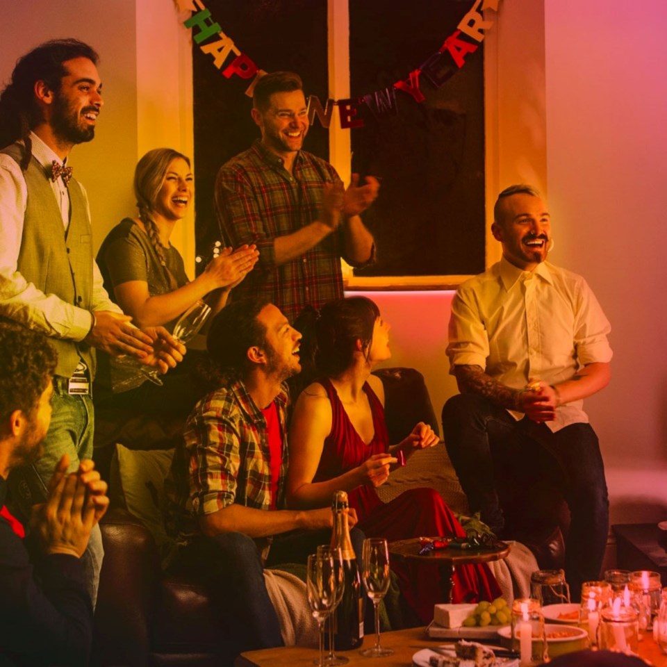 Tapo Tapo L920-5 Smart Light Strip RGB 5m lyser op over indendørs nytårspynt og fest med drinks, snacks og banner.