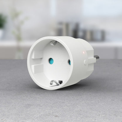 Plejd SPR-01 Smart stik on/off hvid med LED-indikator, to runde stik, Google Home kompatibel på grå bordplade.