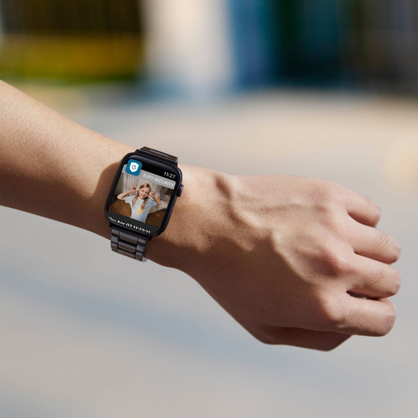 Sort smartwatch på venstre håndled viser indgående videoopkald fra kvinde, kompatibel med Eufy Indendørs kamera 2K Pan  Tilt.