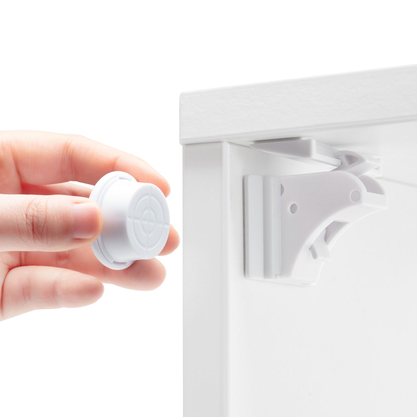 Luxorparts magnetisk lås til skabe/skuffer, 10-pak, hvid, én lås monteret på skab, hånd holder resten.