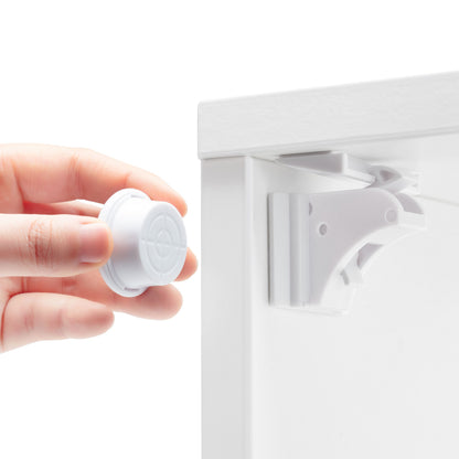 Luxorparts magnetisk lås til skabe/skuffer, 10-pak, hvid, én lås monteret på skab, hånd holder resten.