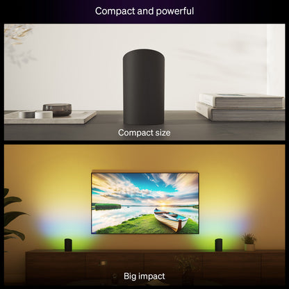 Philips Hue smarthøjttaler på hylde ved TV med stor skærm, oplyst af Philips Hue Spil Wall Washer Vægbelysning.