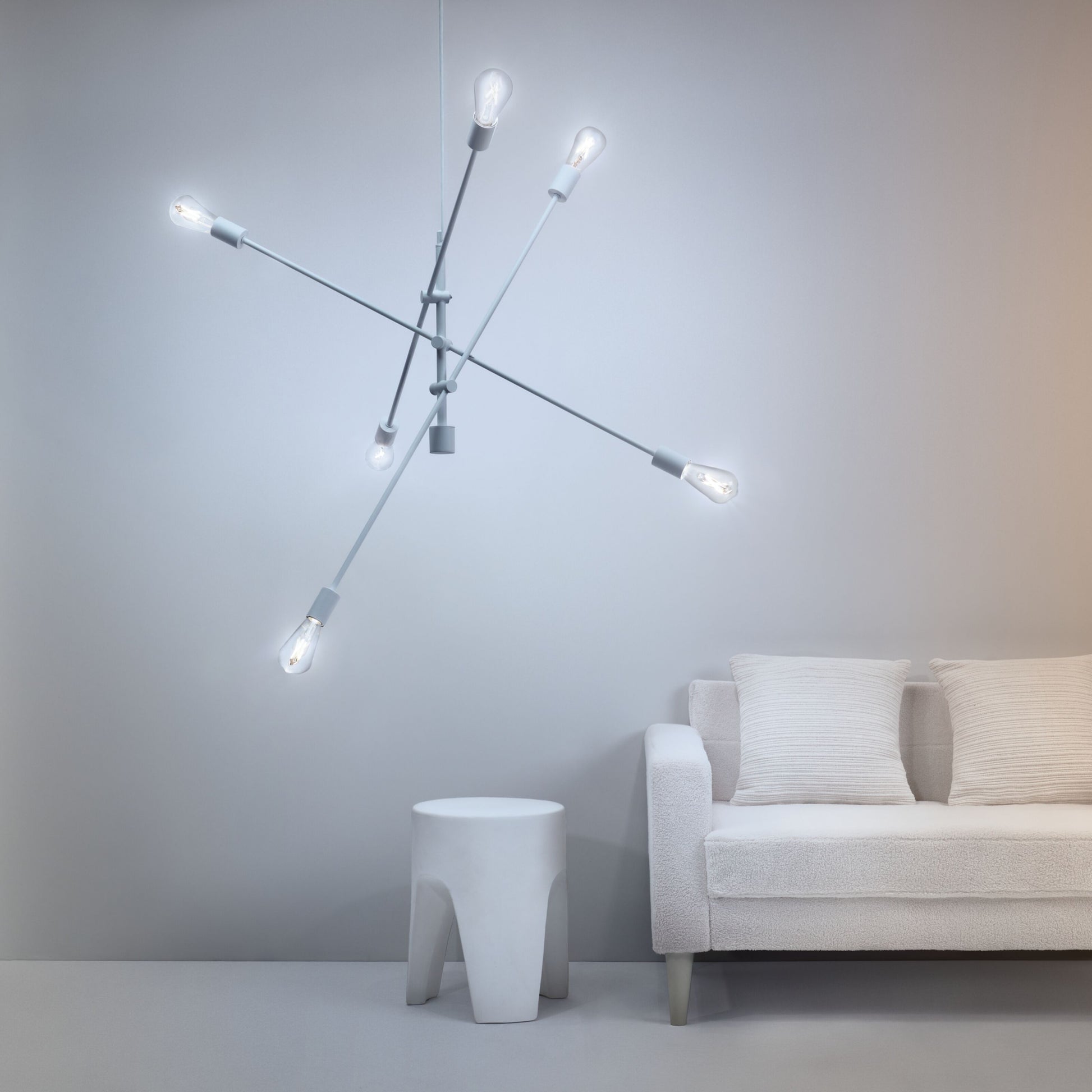 Wiz Amber Filament A60 Smart LED-pære E27 640 lm i stor geometrisk lampe over hvid sofa ved lysegrå væg.