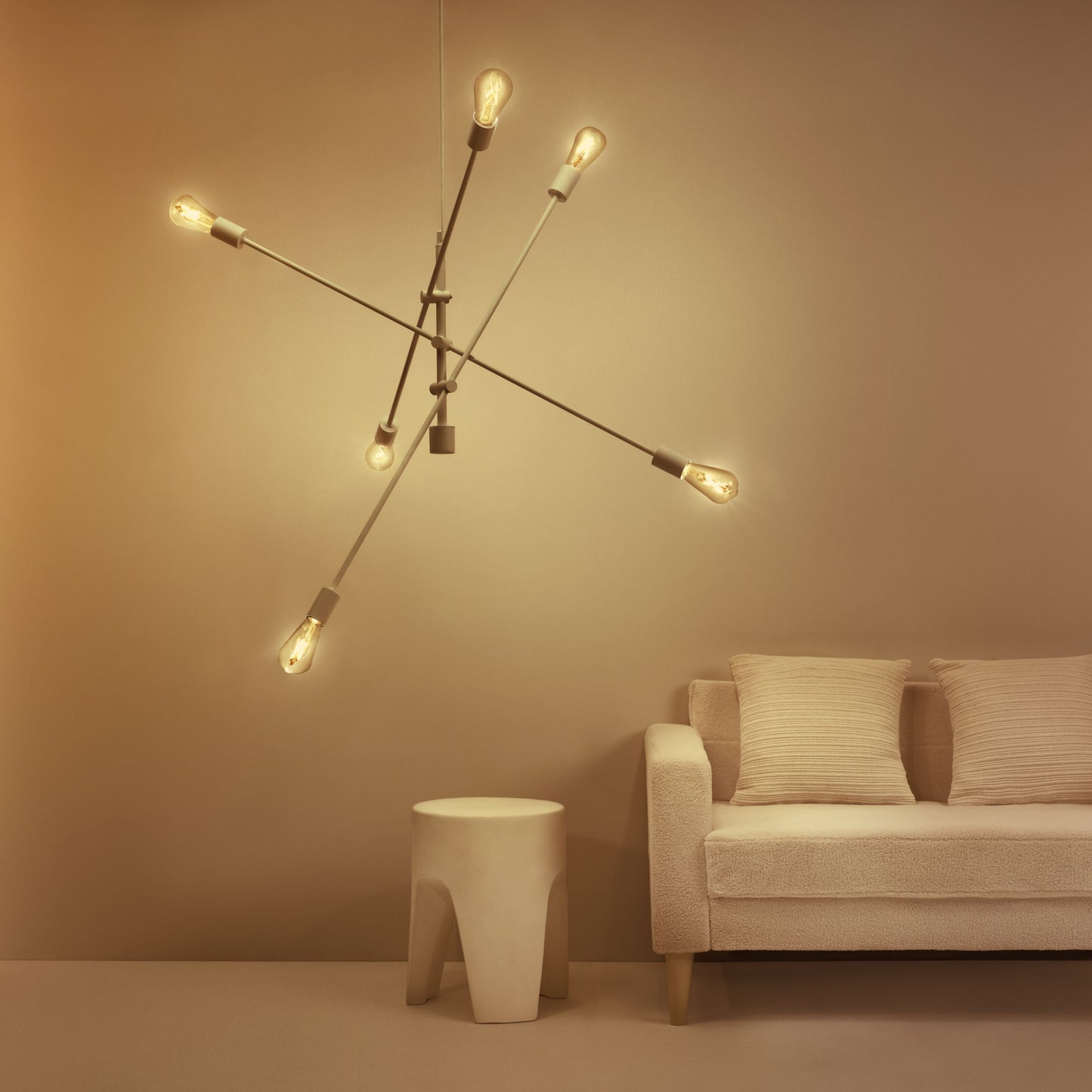 WiZ Klar pære A60 Smart LED-lampe E27 i multi-arm loftlampe, lys creme sofa med to puder, lille hvid cylinderbord.
