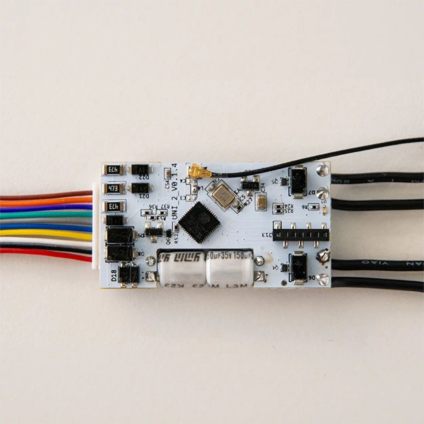 Shelly Plus Uni Smart Wifi-modul på printplade til lavspænding med farvede ledninger, sorte ledninger og små komponenter.