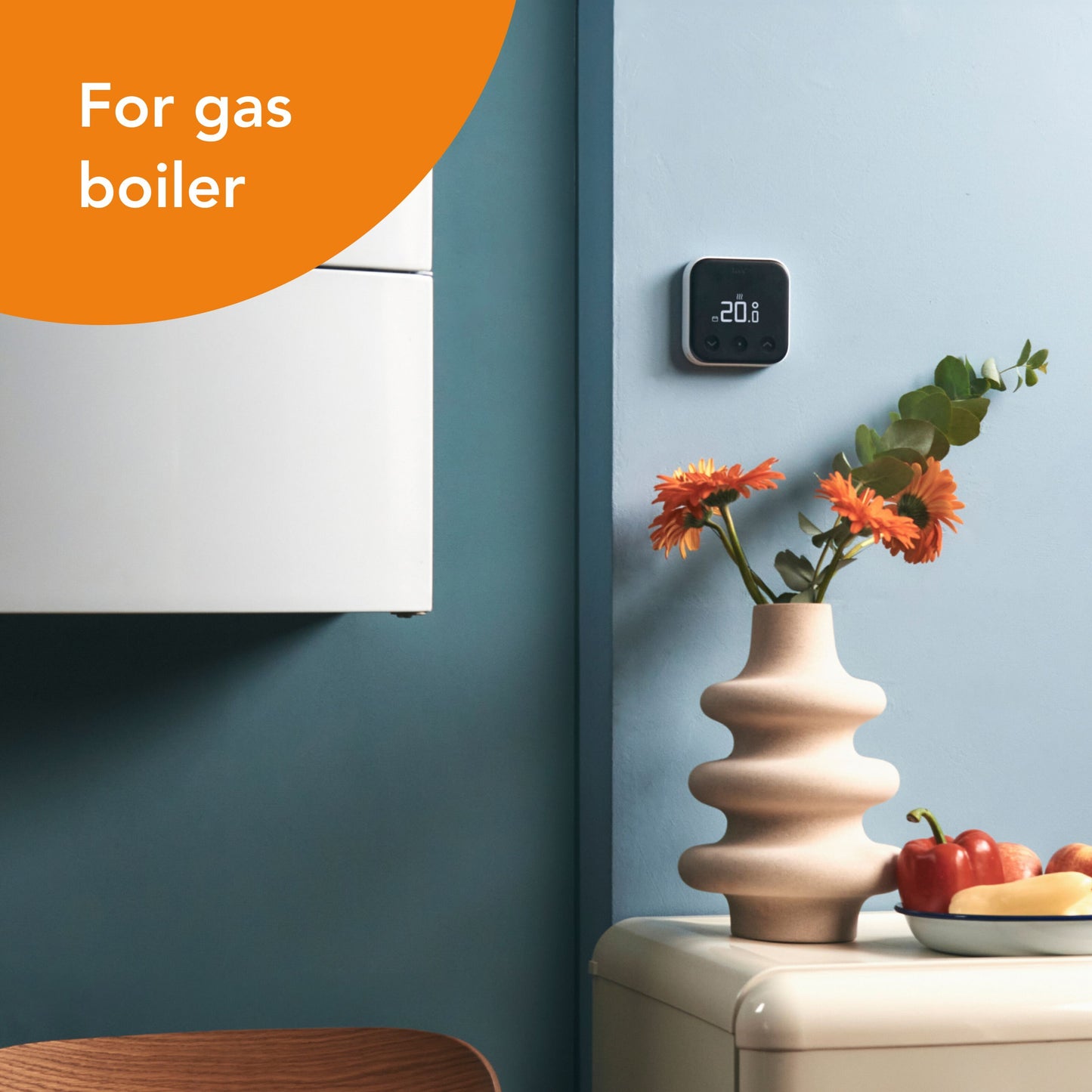 Tado Smart termostat X trådløs viser 20°C på blå væg ved hvid gasfyr, orange mærkning "For gas boiler" synlig.