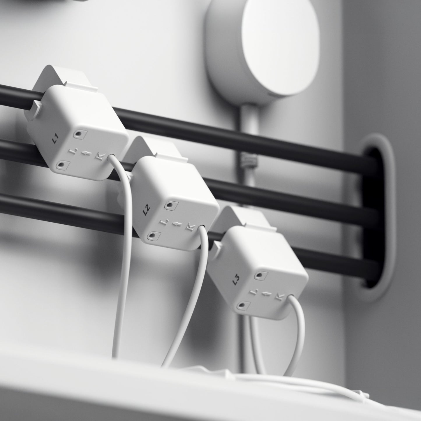 Tre hvide outlet-adaptere mærket L1, L2, L3 tilsluttet sorte kabler og hvide ledninger til Pulse CT realtidsmåler startpakke.