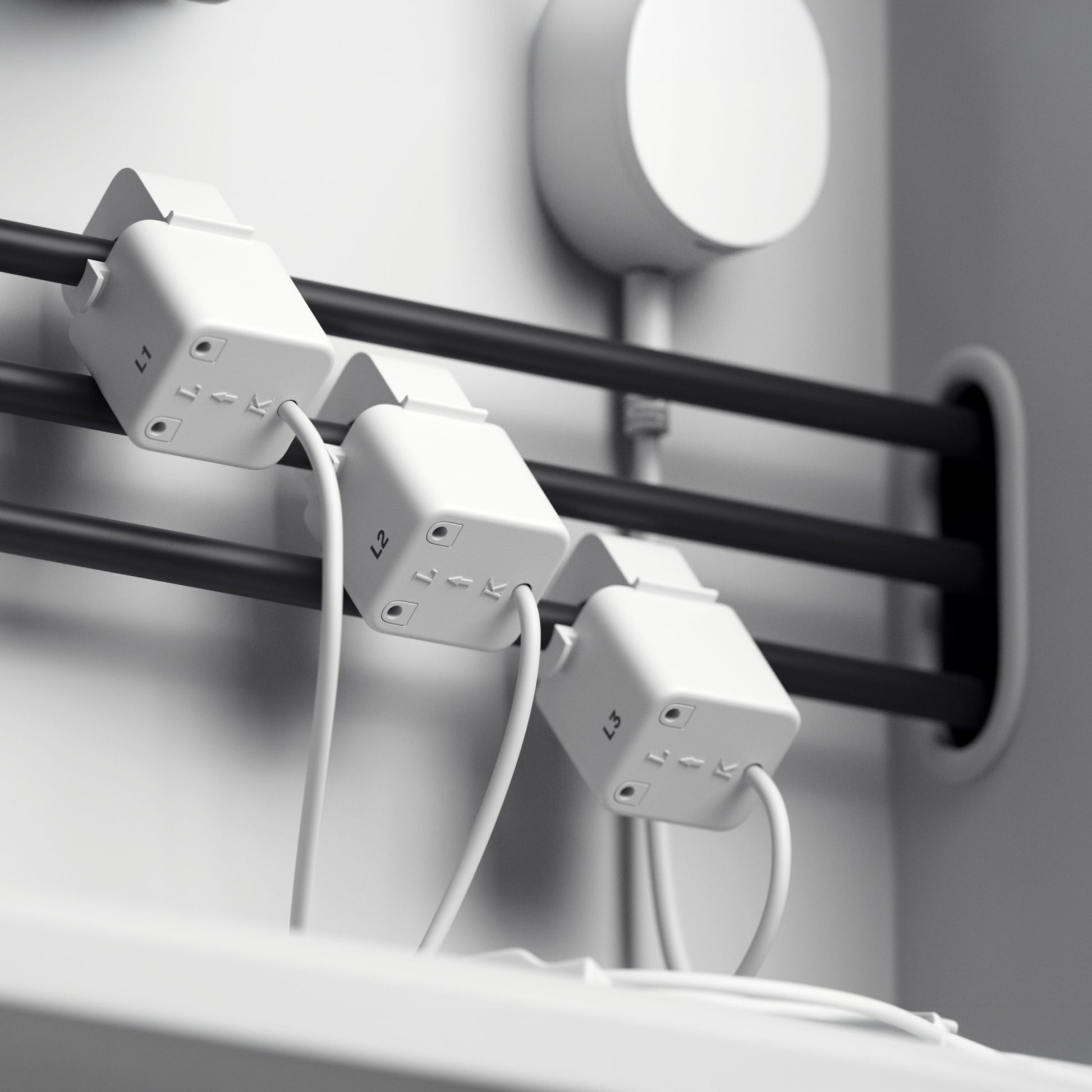 Tre hvide outlet-adaptere mærket L1, L2, L3 tilsluttet sorte kabler og hvide ledninger til Pulse CT realtidsmåler startpakke.