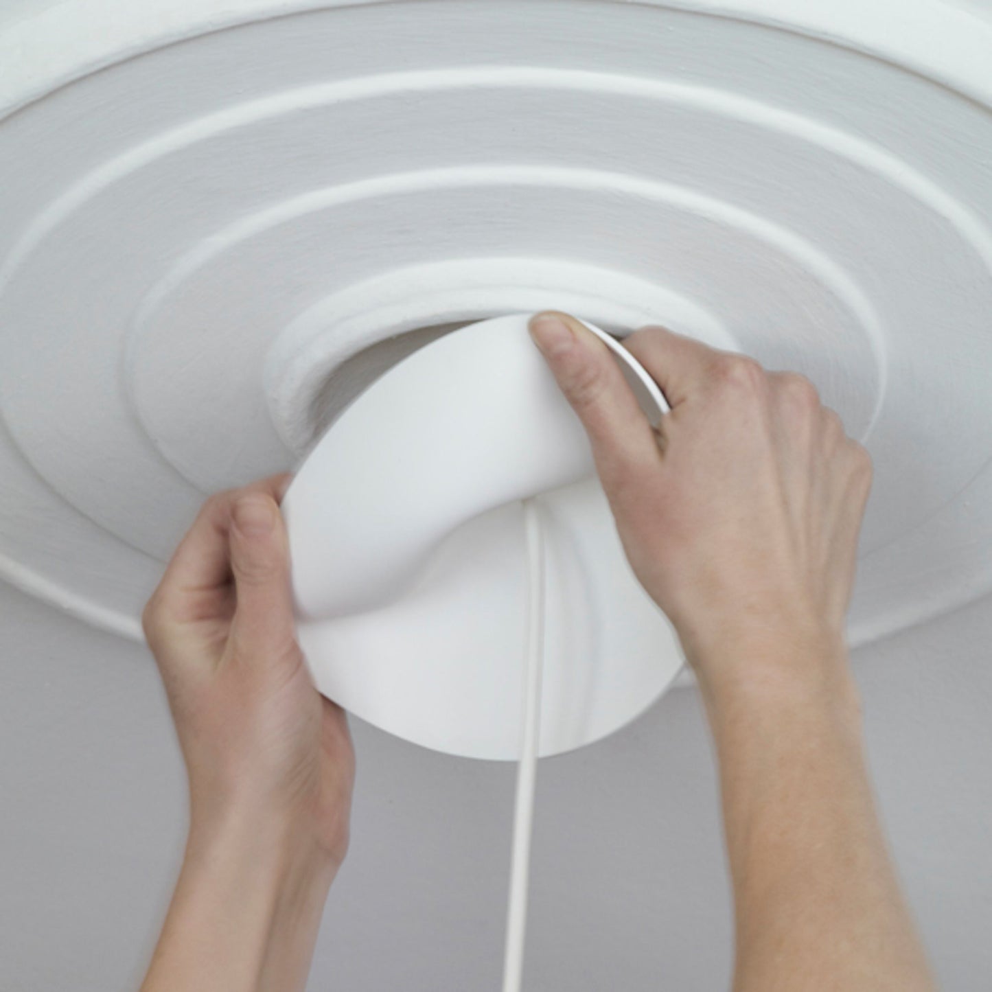 Cablecup Lille hvid Ø125 mm loftroset monteres, fleksibel hvid afdækning justeres rundt om kabel på mønstret loft.
