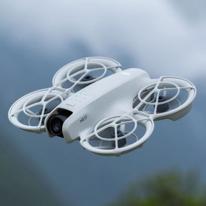 DJI Neo Motion Fly More Combo quadcopter drone med propelbøjler og NEO-logo, udendørs, 4K kamera.