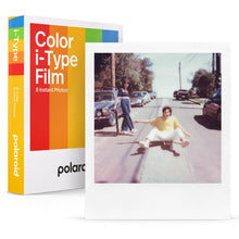 Polaroid Farvefilm til i-Type 40-pakke ved siden af foto taget med i-Type, person i gul trøje på gade.
