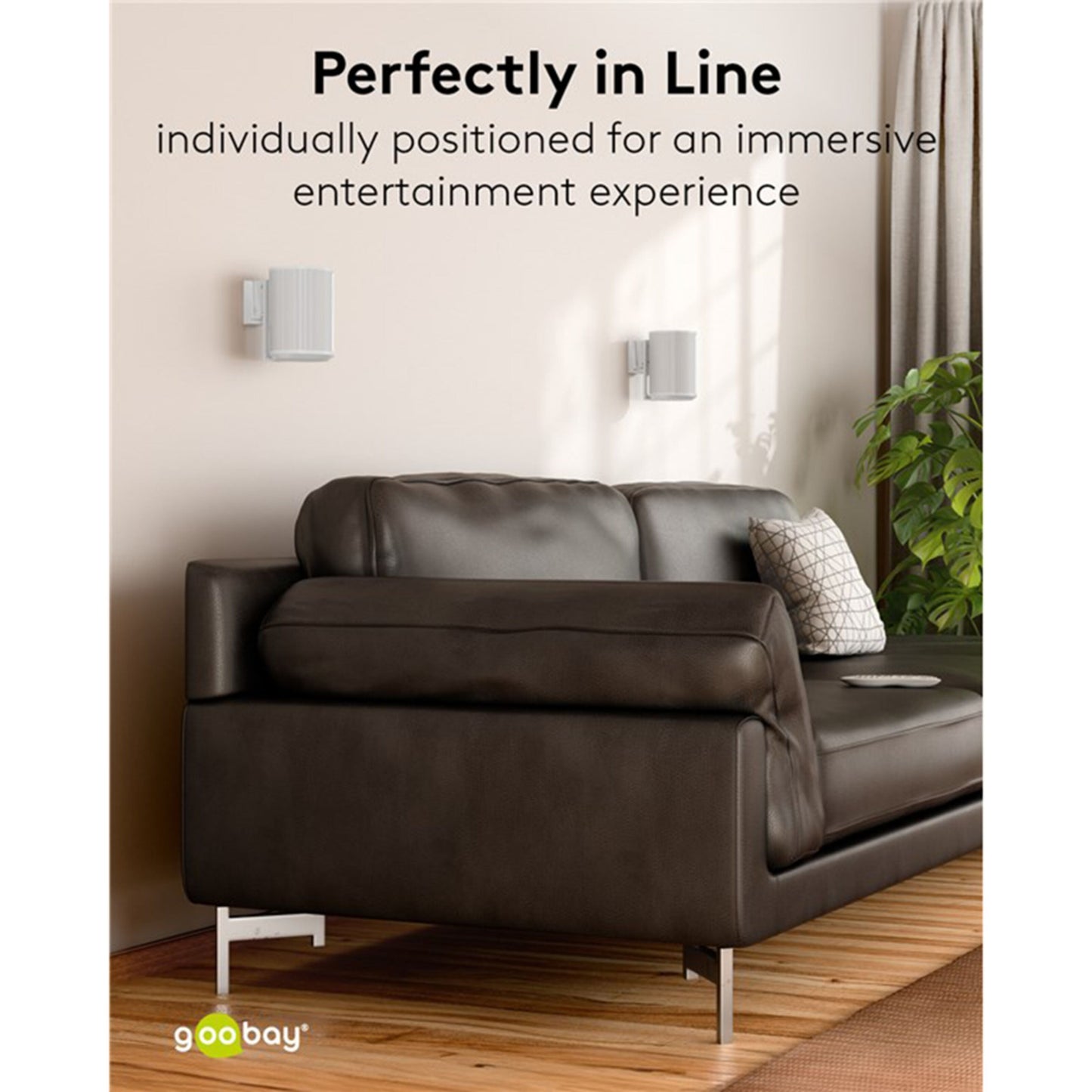 Sonos Era 100 hvid, to stk. vægmonteret med 2-pak beslag, synlig brun lædersofa og sidebord med bog og plante.