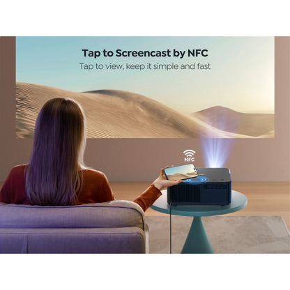 Yaber K2s Premier Theater Full HD-projektor på bord, NFC screencast tekst synlig, sandklitter projiceres.