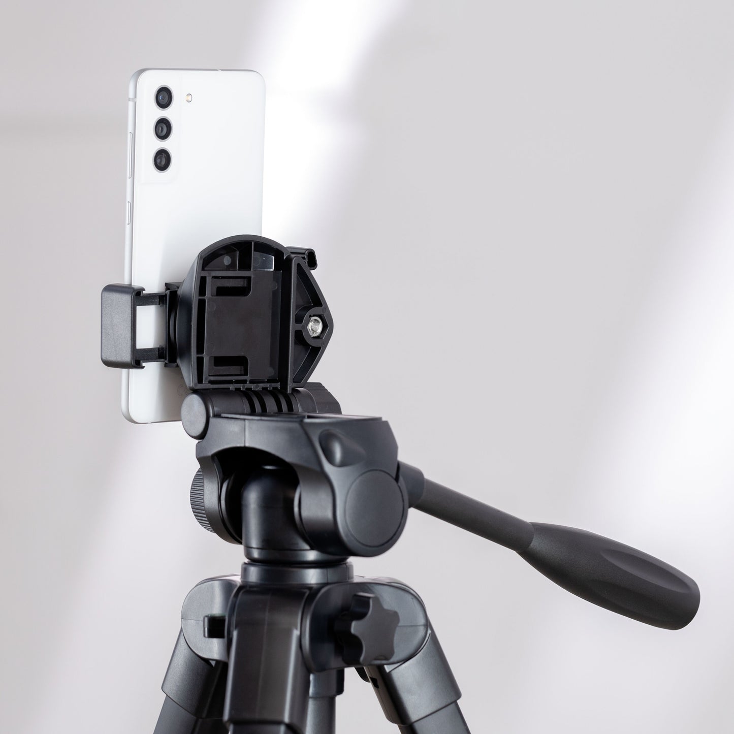 Velbon EX-650 kamerastativ med mobilholder, justerbart håndtag, hvid smartphone monteret.