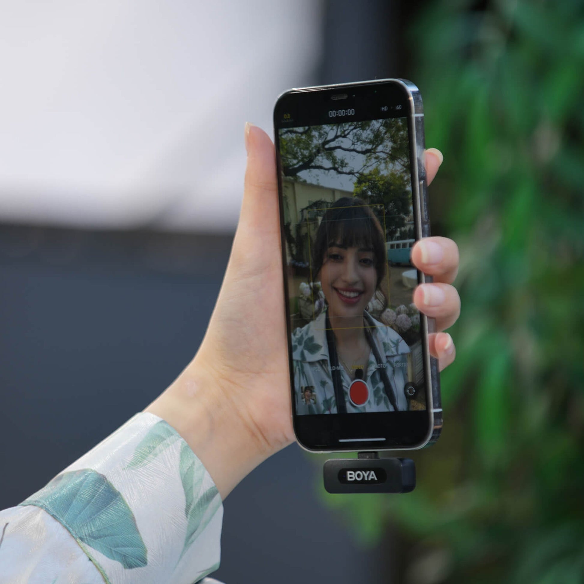 Boya BY-V10 Trådløs Mikrofon USB-C monteret på smartphone, videooptagelse med kvinde vises på skærmen.