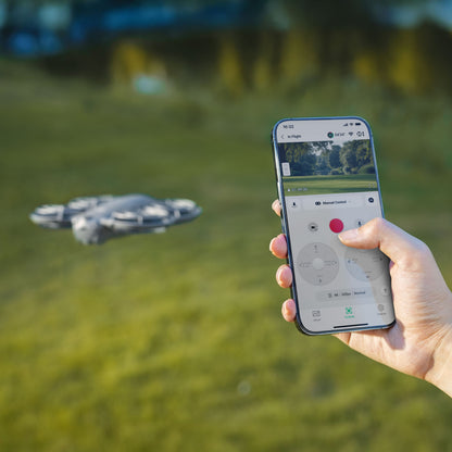 DJI Neo 2 ultralet drone i luften over græs, styres med smartphone, live 4K-video vises på skærmen.