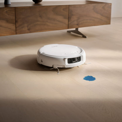 DJI ROMO S robotstøvsuger og moppe med 3D LiDAR på lyst trægulv nær blå plet, moderne trækommode i baggrunden.