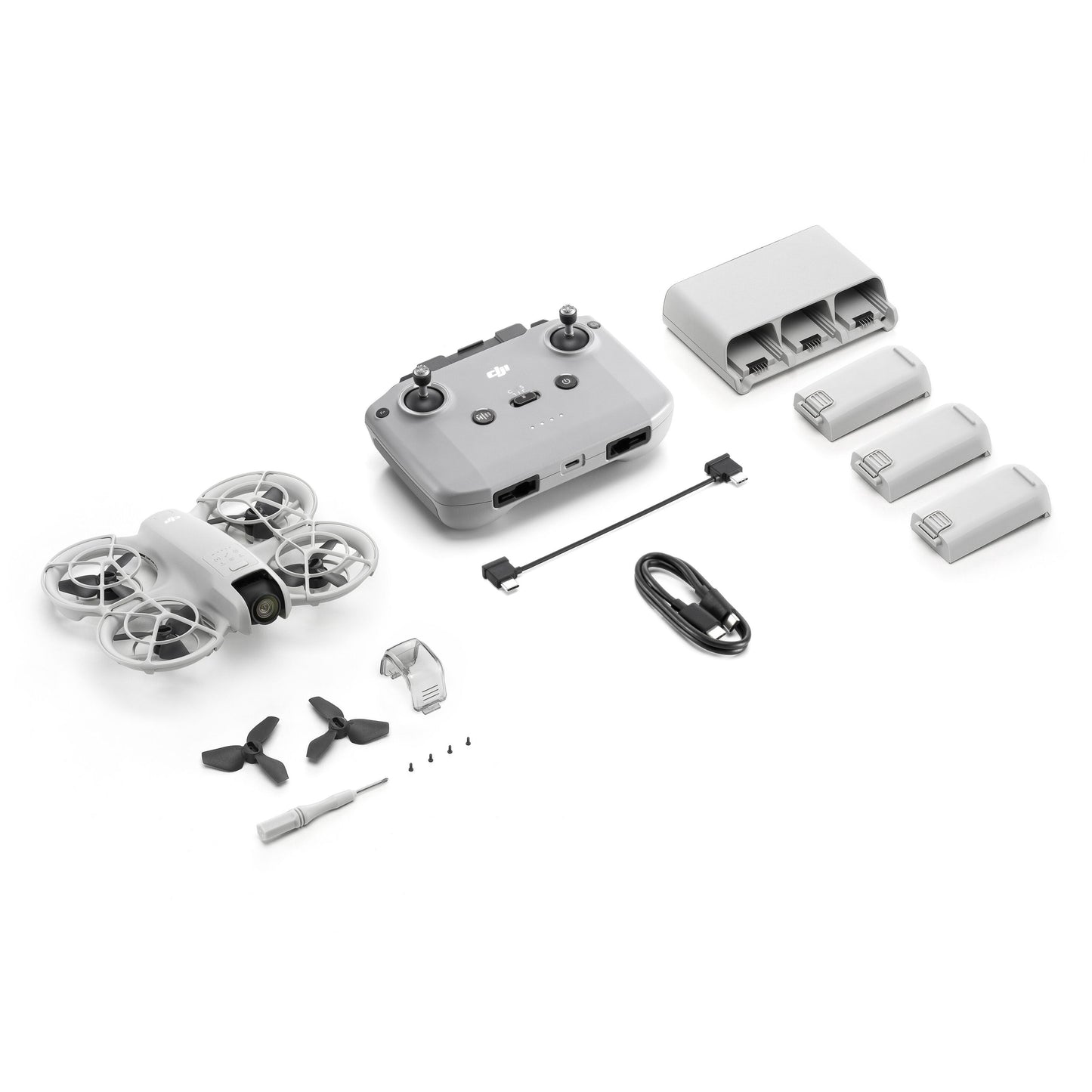 DJI Neo Fly More Combo ultrakompakt drone med controller, ladestation, 3 batterier, kabler, propel og værktøj.