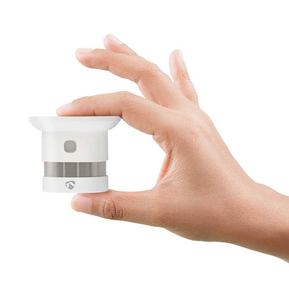 Nedis WiFi Brandalarm 5 år, kompakt røgdetektor med mesh-design ses i hånd, hvid.