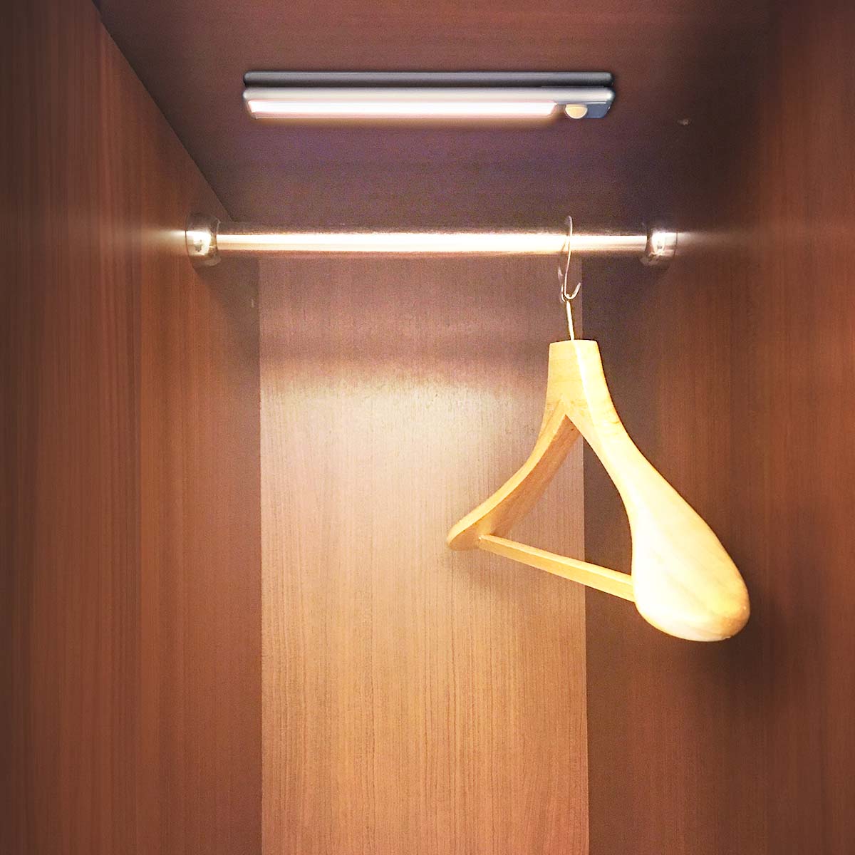 Nedis LED Skabslampe 20cm monteret øverst i træskab med metal bøjlestang og træbøjle, brun indretning.