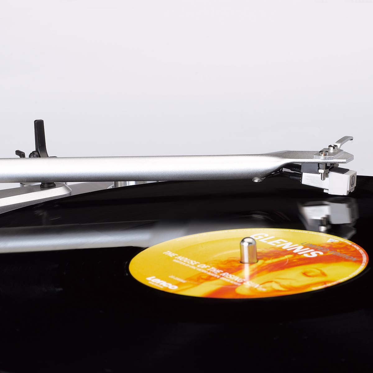 Lenco LBT-188WA Bluetooth pladespiller tonearm og nål på vinyl med gul-orange label, del af kvindes ansigt, "GLENNIS" tekst.