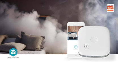 Nedis SmartLife Røgalarm med app vist på smartphone, Powered by Tuya logo synligt, røg i baggrunden.