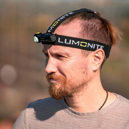 Lumonite Vector V2 pandelampe 500 lm IPX8 på mandens pande udendørs, naturlig baggrund.