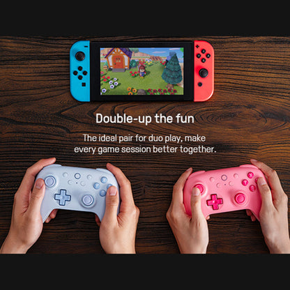 8Bitdo Ultimate 2C trådløse controllere i pastelblå under Nintendo Switch konsol, produktnavn synlig.