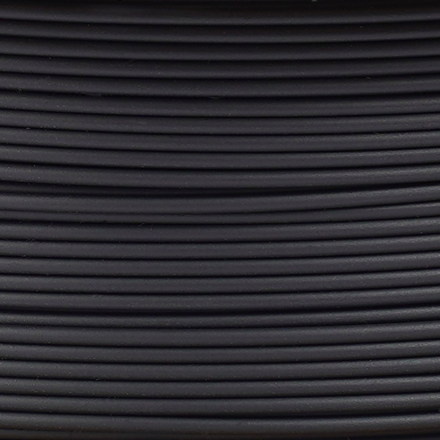 Copymaster3D PLA-filament 1,75 mm sort ruller, tæt oprullede og arrangeret vandret med synlige lys- og skyggeeffekter.