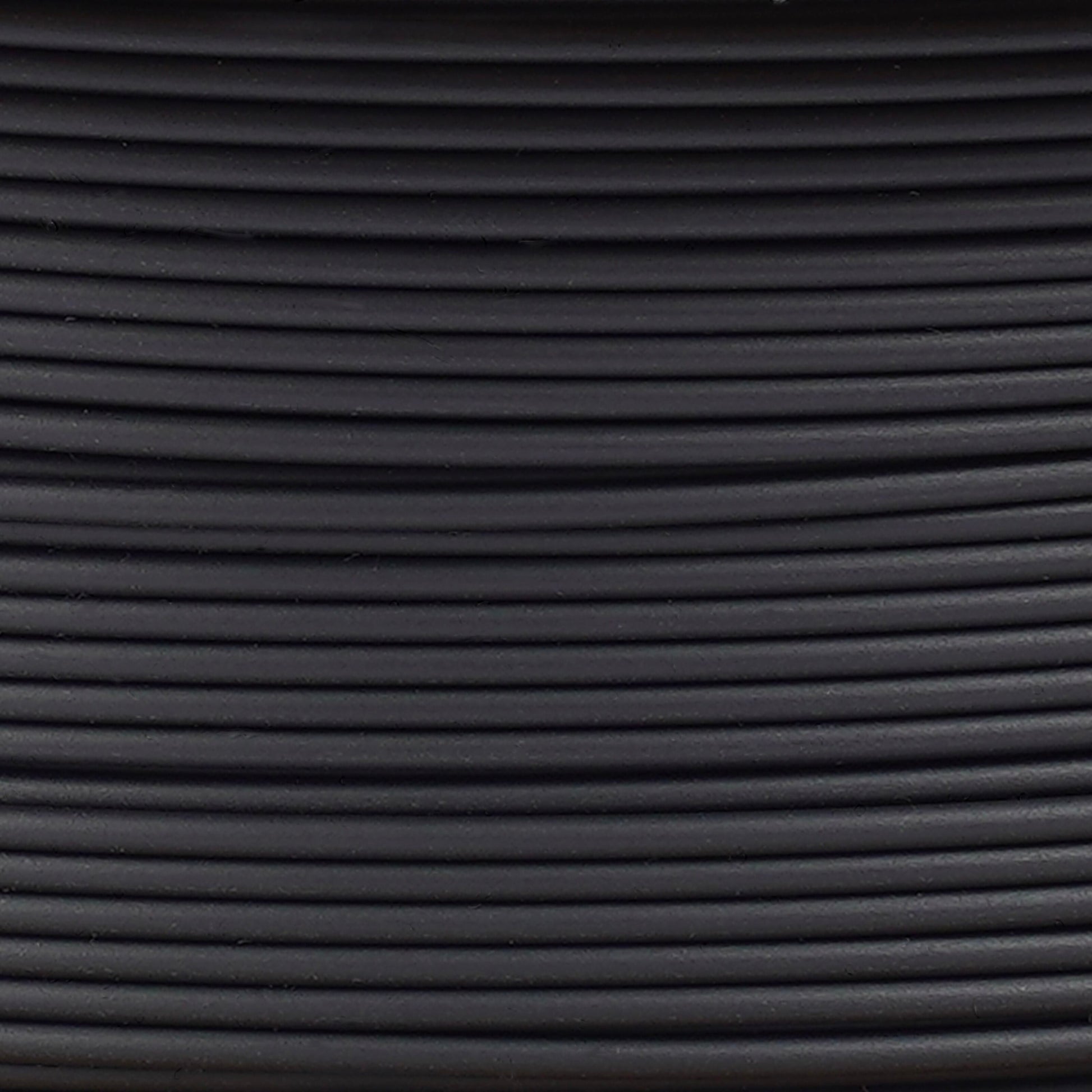 Copymaster3D PLA-filament 1,75 mm sort ruller, tæt oprullede og arrangeret vandret med synlige lys- og skyggeeffekter.