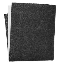 Sort grovkornet sandpapir, let bøjet med det ene hjørne synligt bag det andet, minder om Filter til emhætte Dobbelt.