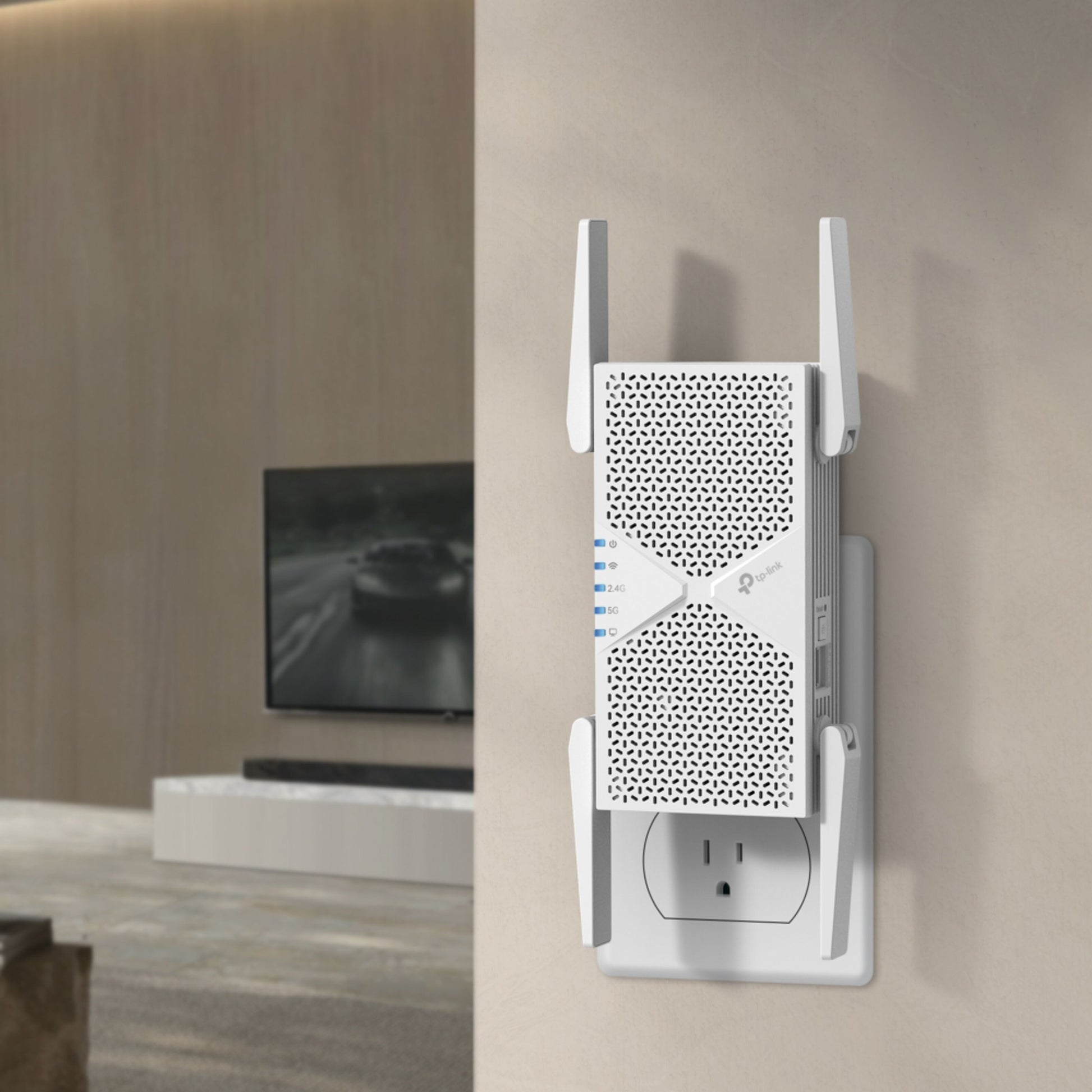 TP-Link RE405BE Wi-Fi 7-repeater BE6500 stikprop, antenner ude, 5 Gbps Ethernet-port synlig, tv-skærm i baggrunden.