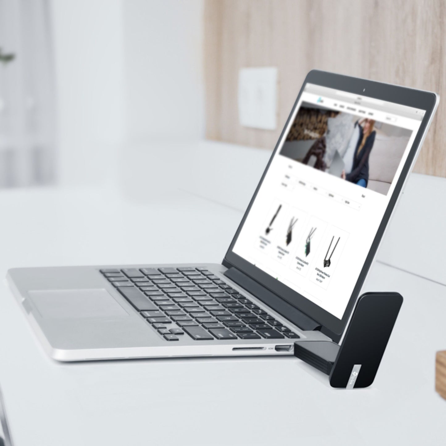 TP-Link Archer T4U Trådløst USB-netværkskort 867 Mb/s tilsluttet sølvlaptop, lys trævæg og stikkontakt i baggrunden.
