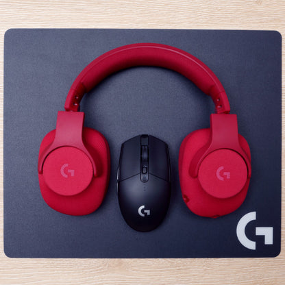 Røde over-ear hovedtelefoner og sort Logitech G305 Lightspeed trådløs gamingmus på sort Logitech musemåtte.