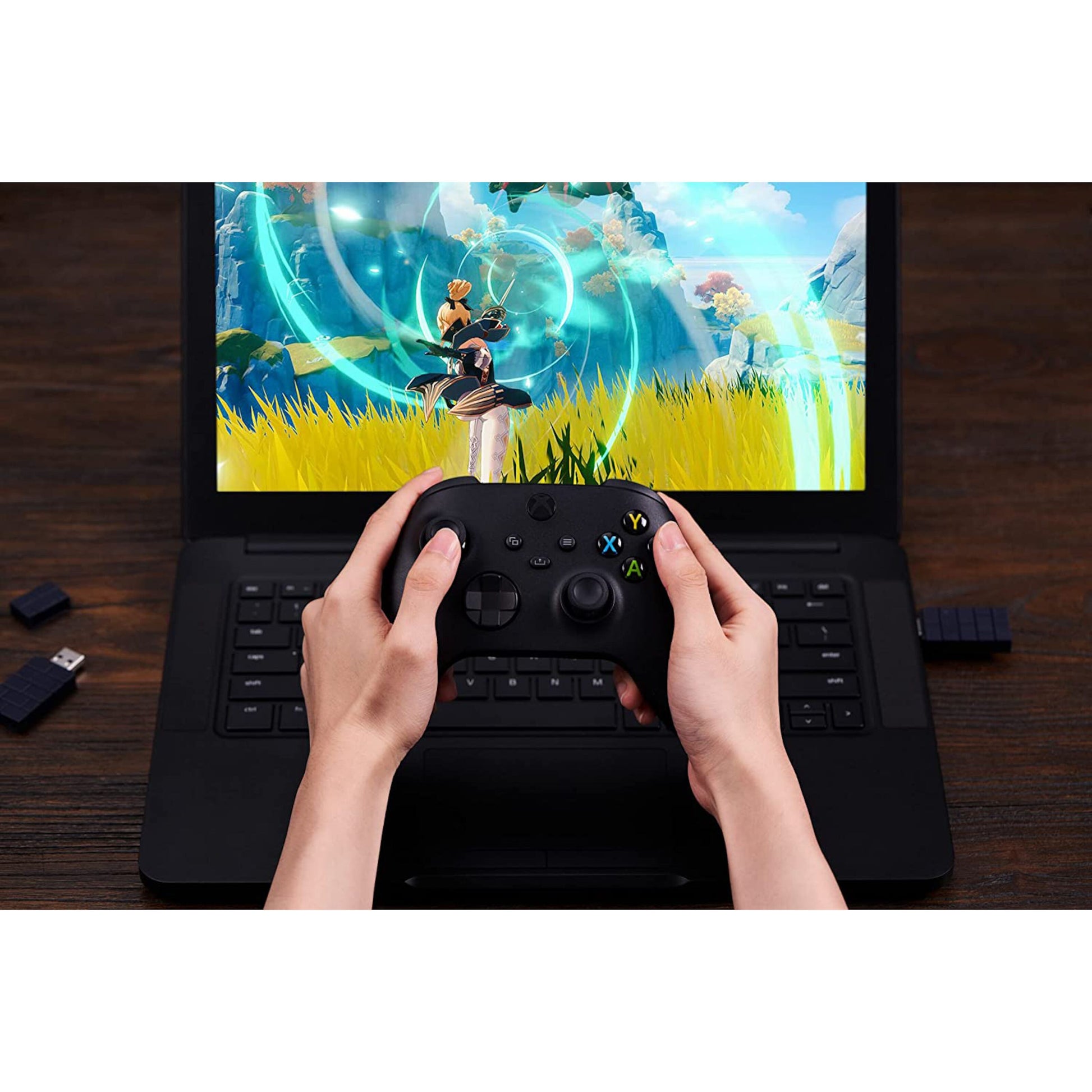 8Bitdo Trådløs USB-adapter 2 tilsluttet laptop, USB-stik synligt, spil med farverig grafik på skærmen.
