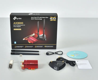 TP-Link Archer TX3000E AX3000 PCIe netværkskort med Bluetooth 5, antenner, base, kabler, CD, brugervejledning og æske.