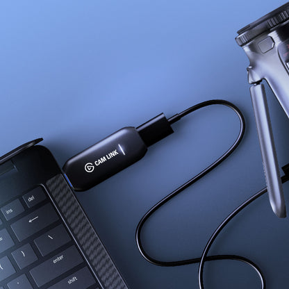 Elgato Cam Link 4K kameraadapter HDMI til USB, eksternt kamera, bærbar computer, blå baggrund.