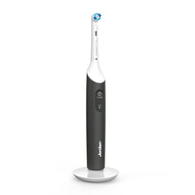 Jordan Clean Smile Plus elektrisk tandbørste sort/hvid, synlig power-knap og rund børstehoved på hvid opladerbase.