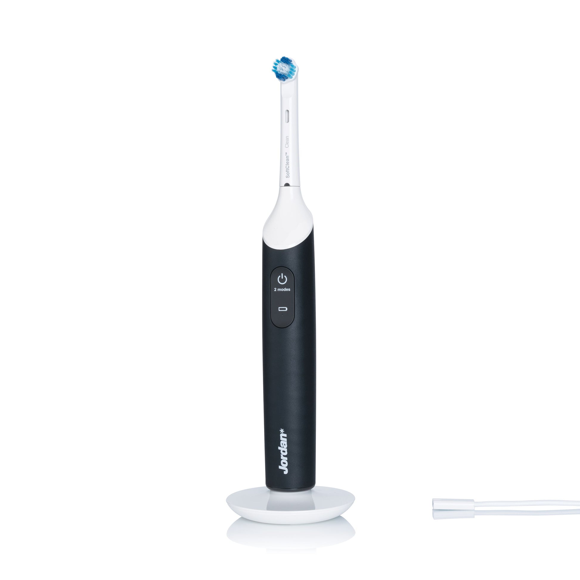 Jordan Clean Smile Plus elektrisk tandbørste med lille rundt børstehoved, synlig power-knap og brandnavn på opladerstation.