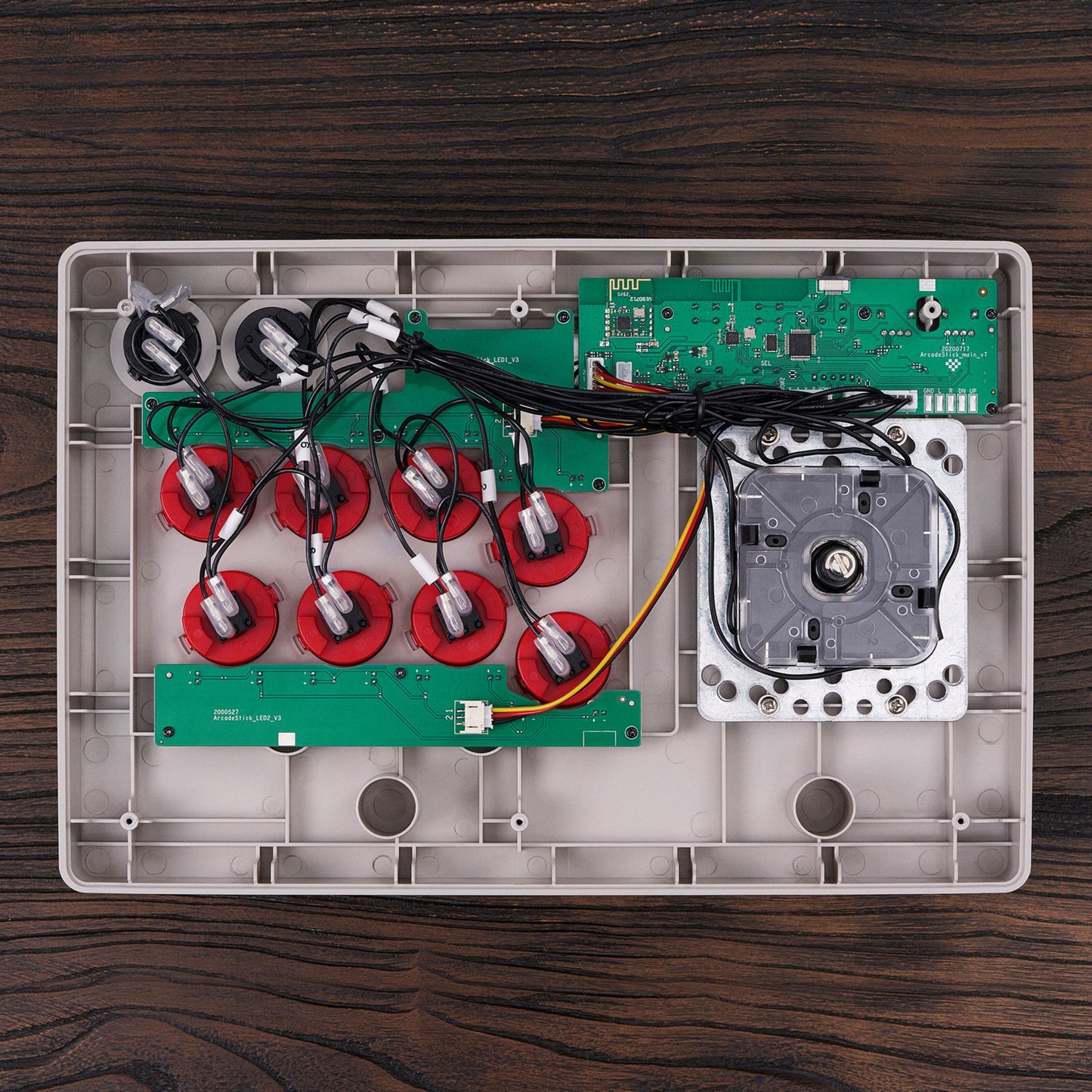 8Bitdo Arkade joystick åben med synlige interne ledninger, printplader, knapper og Nintendo Switch joystick-enhed.