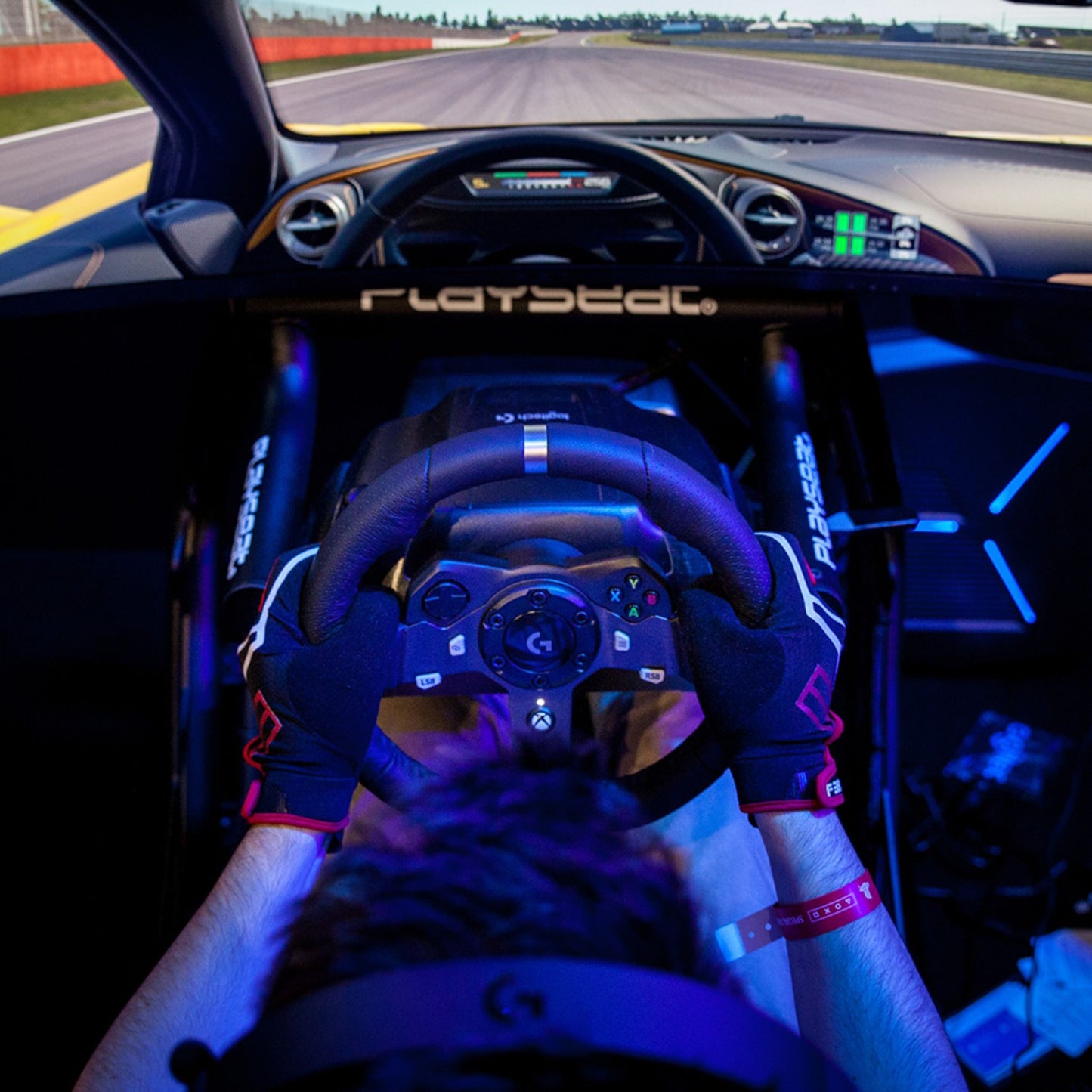 Logitech G 920 Driving Force rat til Xbox og PC monteret i PlayStation-racingsimulator, virtuel racerbane på skærm.