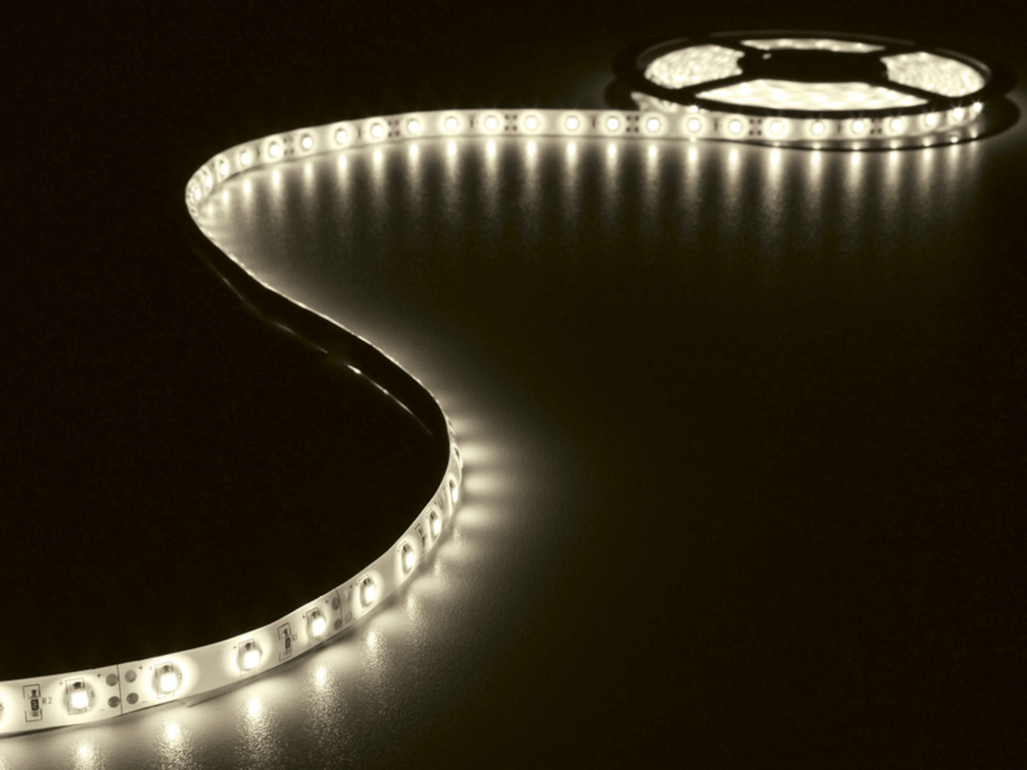 Ledsavers LED-strip Hvid 3 m med varm hvidt lys i rulle, placeret på mørk overflade.