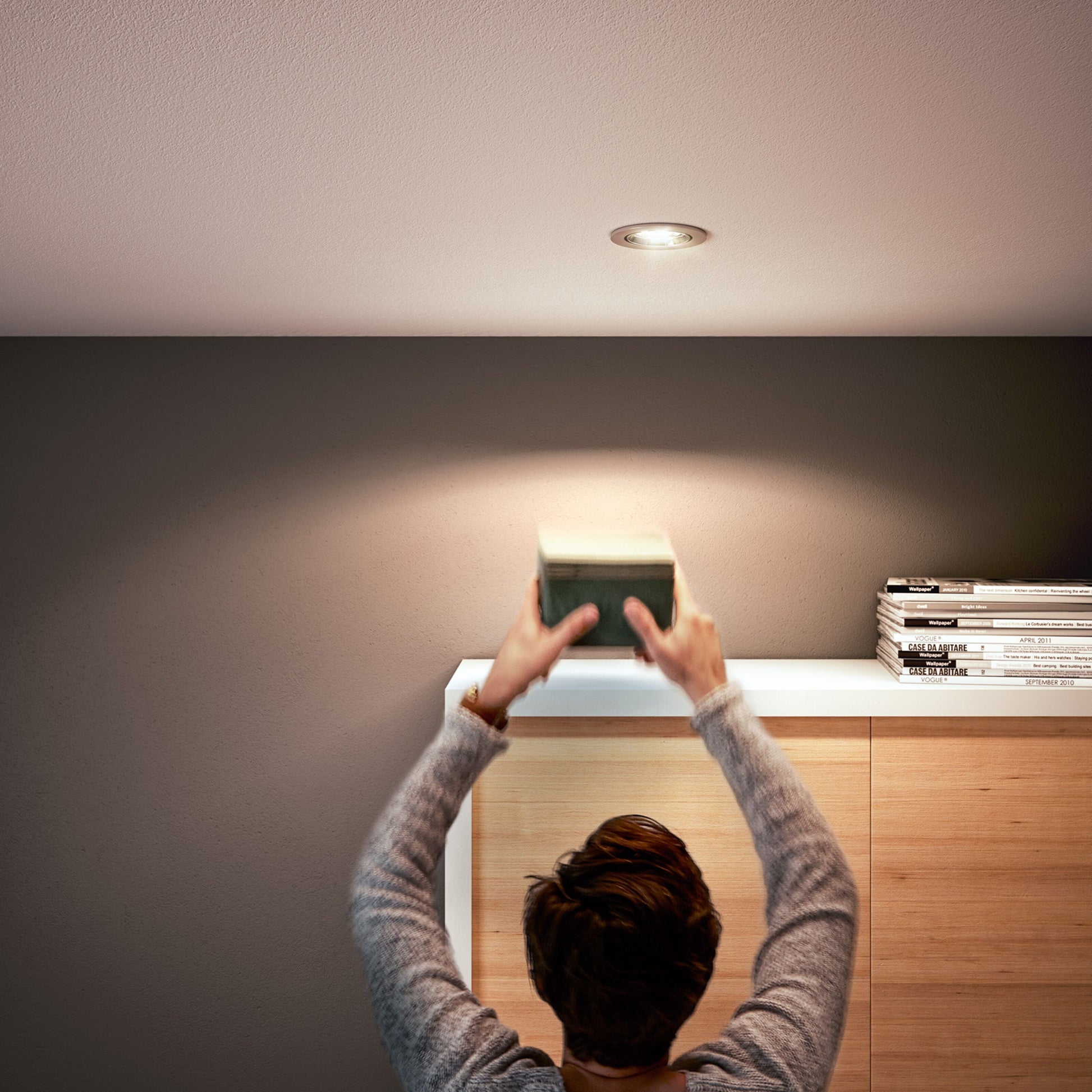 Philips LED-pære GU5,3 345 lm spotbelysning monteret over træskab med magasiner og lille papæske.