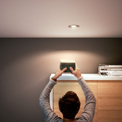 Philips LED-pære GU5,3 345 lm spotbelysning monteret over træskab med magasiner og lille papæske.