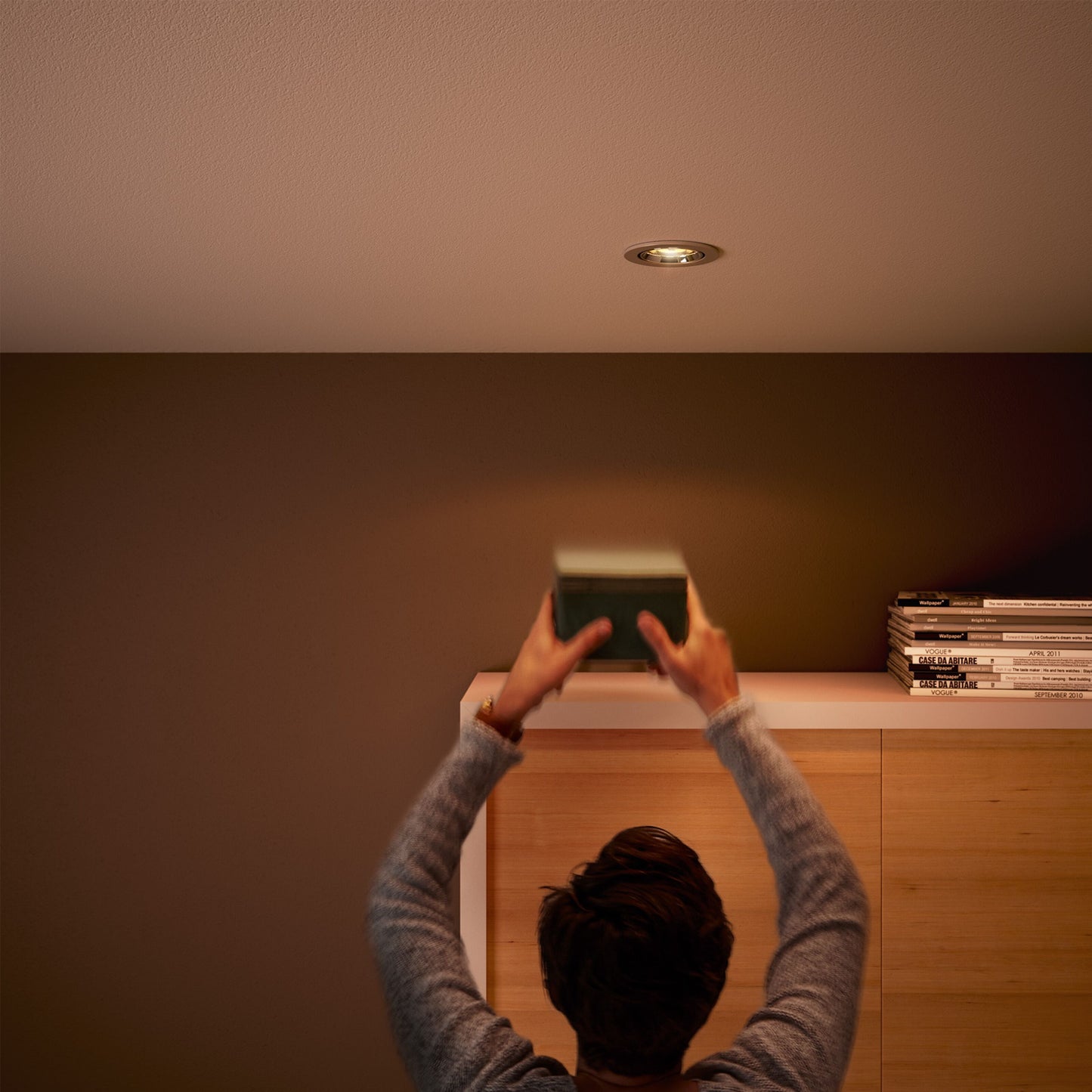 Philips LED-pære GU5,3 345 lm varm hvid dæmpbar spotbelysning over reol med bøger og magasiner.
