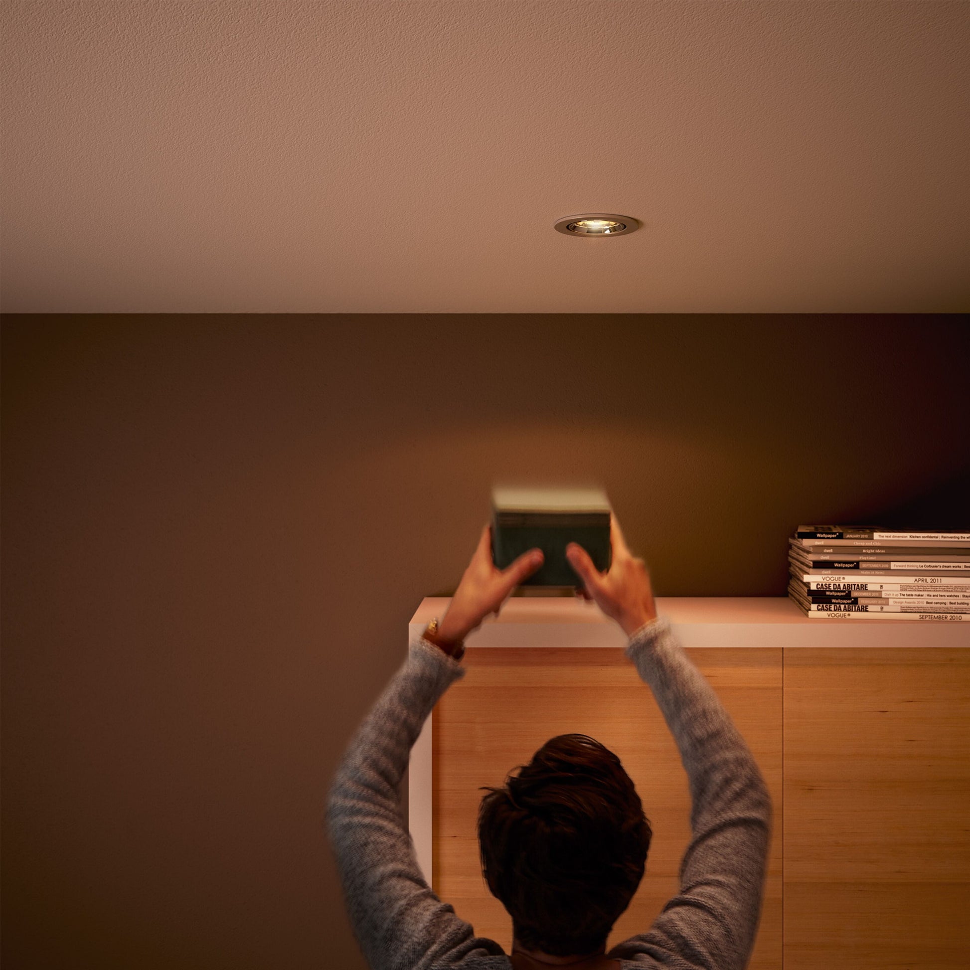 Philips LED-pære GU5,3 345 lm varm hvid dæmpbar spotbelysning over reol med bøger og magasiner.