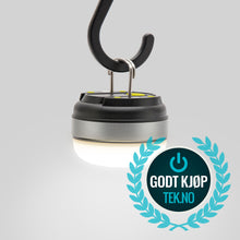 Ledsavers Mini-campinglampe hænger fra krog med blåt GODT KJØP TEK.NO logo med strømsymbol i forgrunden.